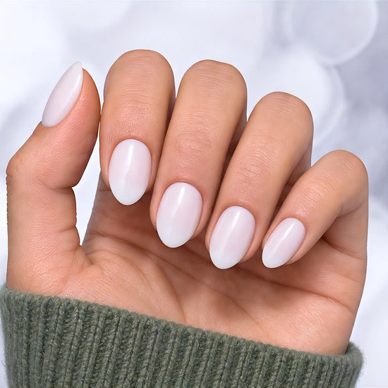 Palm-forward view of semi-translucent milky white press-on nails in a short almond shape, highlighting the soft, sheer "jelly" nail effect.