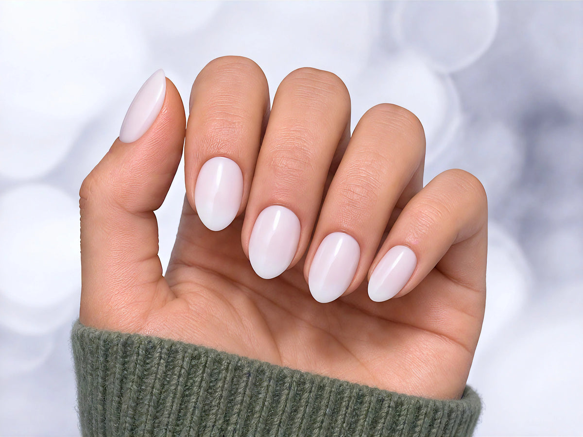Palm-forward view of semi-translucent milky white press-on nails in a short almond shape, highlighting the soft, sheer "jelly" nail effect.