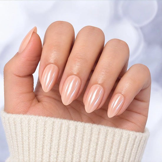 Palm-facing shot of pearlescent pink chrome short almond press-on nails, showcasing the iridescent, shimmering light-reflective finish.