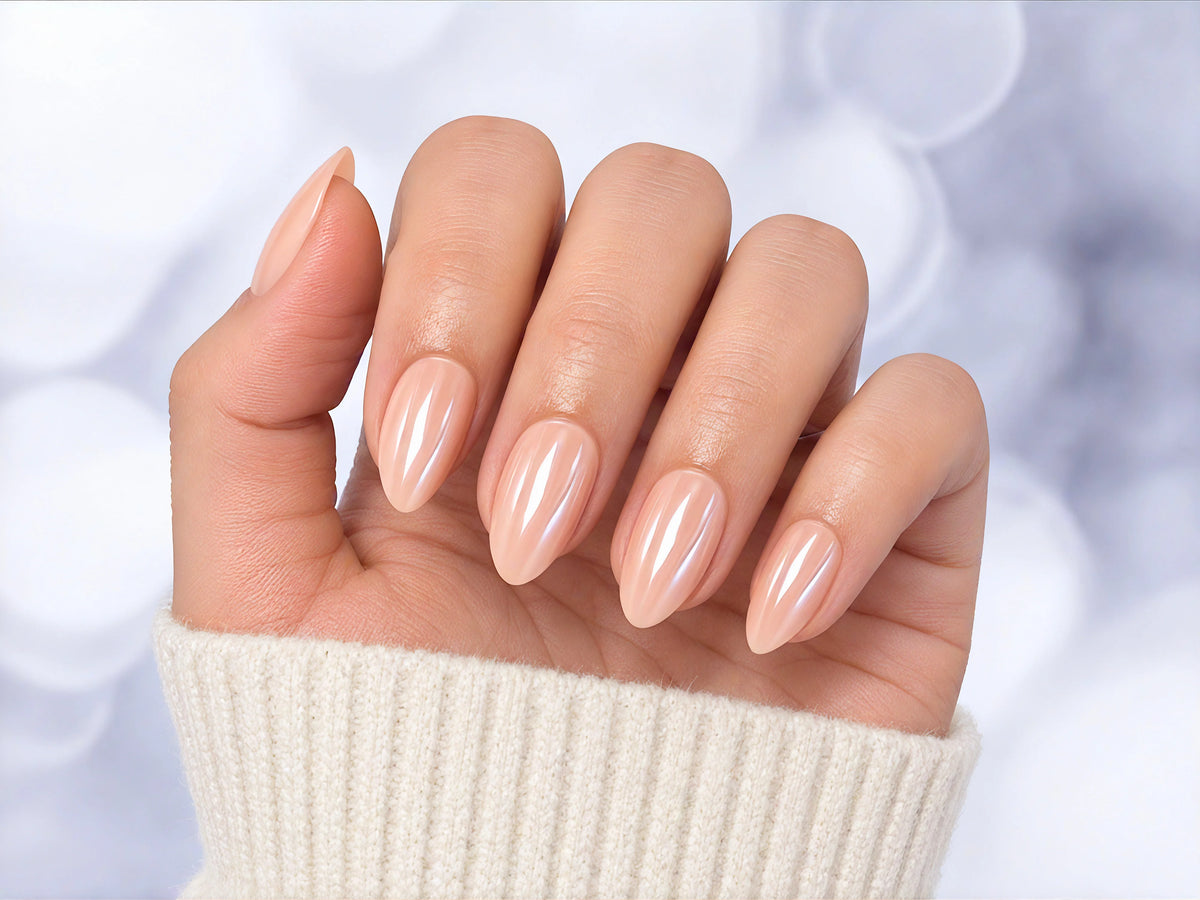 Palm-facing shot of pearlescent pink chrome short almond press-on nails, showcasing the iridescent, shimmering light-reflective finish.