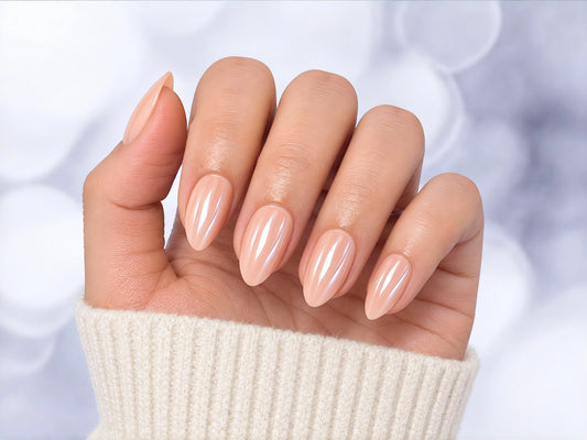 Palm-facing shot of pearlescent pink chrome short almond press-on nails, showcasing the iridescent, shimmering light-reflective finish.