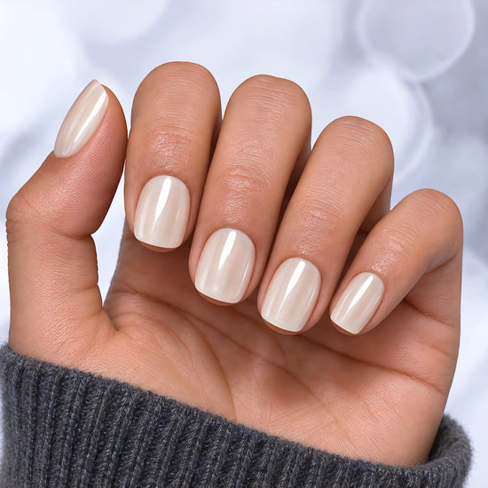 Relaxed palm view of white pearlescent chrome press-on nails in a short square shape, showcasing the reflective pearl shimmer.