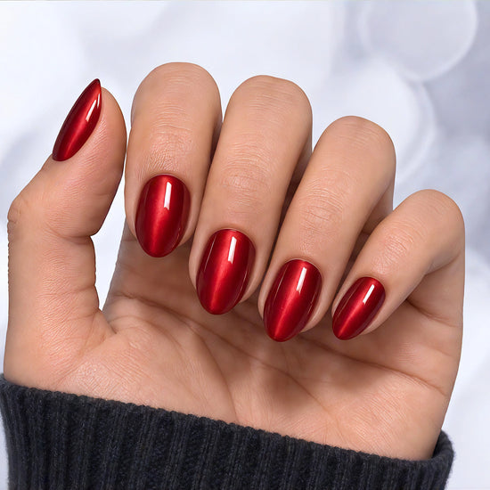 A palm-facing view of ruby red velvet chrome short almond press-on nails, showing the deep 3D cat-eye texture and reflective shine.