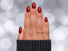 A top-down shot of ruby red velvet chrome short almond press-on nails, highlighting the rich magnetic shimmer and almond silhouette.