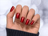 Relaxed hand pose showcasing short square ruby red velvet chrome press-on nails with a luxurious magnetic velvet effect.