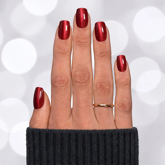 Top-down view of short square shaped ruby red velvet chrome press-on nails, capturing the multidimensional deep red metallic finish.