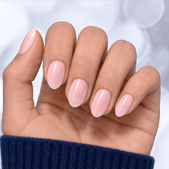 Palm-forward shot of sheer soft pink press-on nails in a short almond shape, emphasizing the natural, translucent "your nails but better" look.